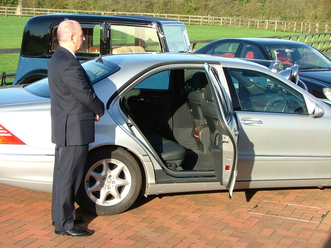 Picture of chauffeur with Mercedes Benz and classic Rolls Royce